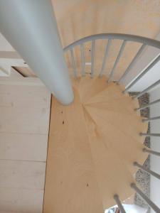 a spiral staircase in a house with a wooden floor at Salento Rooms in Leverano