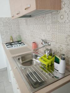 a kitchen sink with a yellow dish rack next to it at Salento Rooms in Leverano