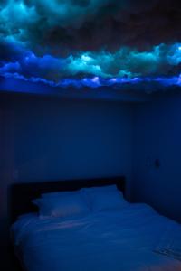a blue room with a bed with a cloud painted on the ceiling at Nimbus Cloud King Suite W/ Great Access to City in Philadelphia