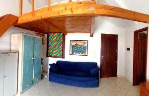 a blue couch in a room with a wooden ceiling at Residencial Ilha do Fogo app 205 in Santa Maria