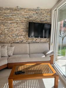a living room with a couch and a tv on a brick wall at Apartments Lili Flora in Zadar