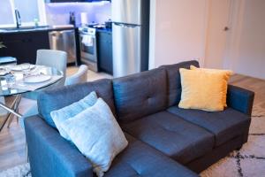 a blue couch with two pillows sitting in a living room at Nimbus Cloud King Suite W/ Great Access to City in Philadelphia