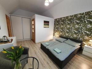 1 dormitorio con 1 cama y una gran pared de plantas en MTK Pokoje i Apartamenty, en Smołdzino
