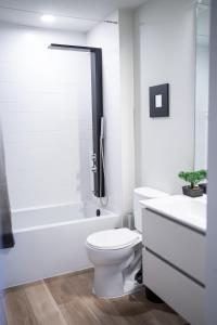 a white bathroom with a toilet and a bath tub at Nimbus Cloud King Suite W/ Great Access to City in Philadelphia