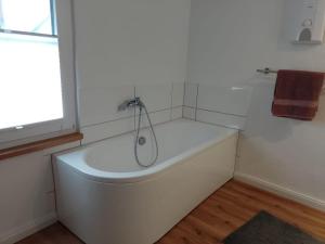 a white bath tub in a bathroom with a window at Landhaus Laux in Schmitt