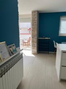 eine Küche mit blauen Wänden sowie einem Tisch und Stühlen in der Unterkunft Apartments Lili Flora in Zadar
