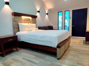 a bedroom with a large bed with a white bedspread at Hotel Boutique Eden Costa in Santa Cruz Huatulco