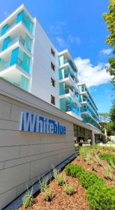 a building with a sign in front of it at Apartament Whiteblue Dream 2 Kołobrzeg z ogródkiem & sauna & fitness & bawialnia dla dzieci in Kołobrzeg +17 photos