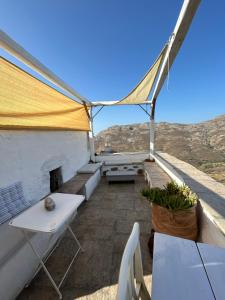 un patio en la azotea con una mesa y una tienda de campaña en Open Space House at the Castle of Chora, Serifos, en Serifos Chora