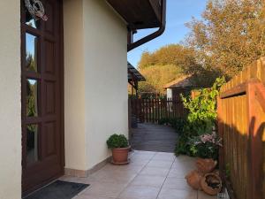 a house with a wooden door and a walkway at Szivárvány Vendégház in Vértestolna