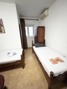 two beds in a room with towels on them at Restaurant & Apartments JUG in Sutomore