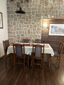 a dining room with a table and chairs and a brick wall at Restaurant & Apartments JUG in Sutomore
