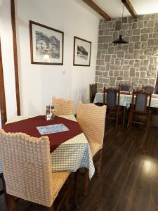 a dining room with tables and chairs and a brick wall at Restaurant & Apartments JUG in Sutomore