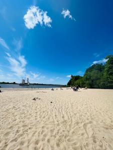uma praia com pessoas sentadas na areia em Top Lage - Bali-Appartment Hamburg em Hamburgo