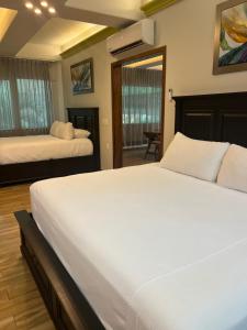 a large bedroom with two beds and a mirror at Puerto Vallarta South Shore Luxury Suites, in Puerto Vallarta