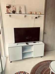 un centro di intrattenimento bianco con TV a schermo piatto di Apartamento céntrico Plazuela a Barranquilla
