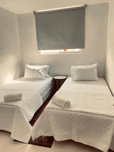 dos camas sentadas una al lado de la otra en una habitación en Apartamento céntrico Plazuela, en Barranquilla