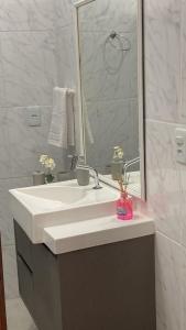 y baño con lavabo blanco y espejo. en Apartamento novo no Flamengo, en Río de Janeiro