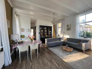 a living room with a couch and a table with chairs at De Consistorie in Giethoorn