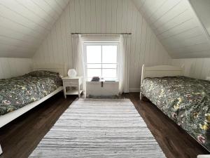 a attic room with two beds and a window at De Consistorie in Giethoorn