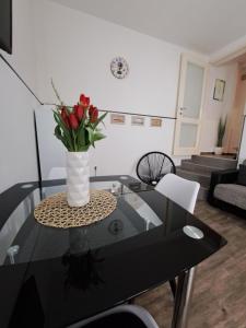 une table en verre avec un vase de fleurs dessus dans l'établissement Kuća za odmor Eni ****, à Šibenik