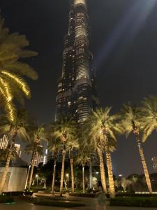un edificio alto con palmeras delante en OMAR HOSTEL FOR BOYS en Dubái