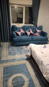 un sofá azul con almohadas en la sala de estar en OMAR HOSTEL FOR BOYS en Dubái