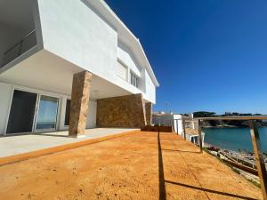 een groot wit huis met uitzicht op het water bij Platja La Fosca in Palamós