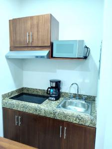 a kitchen with a sink and a microwave at Hotel Boutique Eden Costa in Santa Cruz Huatulco