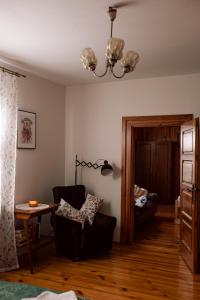 a living room with a chair and a table and a chandelier at Agroturystyka Łączka in Harasiuki