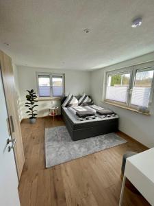 a bedroom with a bed in a room with windows at Anitas Ferienwohnung in Meßkirch