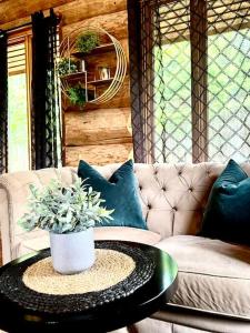un soggiorno con divano e tavolo con piante di Chalets Terre de L'Orme Chalet Bois Rond 2 a Saint-Gabriel-De-Valcartier