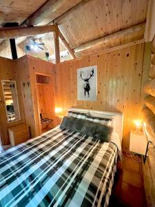 a bedroom with a bed in a wooden room at Chalets Terre de L'Orme Chalet Bois Rond 2 in Saint-Gabriel-De-Valcartier