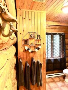 a bathroom with a wooden wall with hangers on it at Chalets Terre de L'Orme Chalet Bois Rond 2 in Saint-Gabriel-De-Valcartier