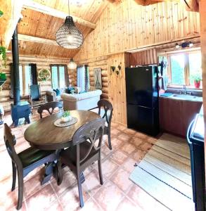 a kitchen and living room with a table and a dining room at Chalets Terre de L'Orme Chalet Bois Rond 2 in Saint-Gabriel-De-Valcartier