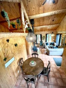 una sala de estar con mesa y sillas en una cabaña en Chalets Terre de L'Orme Chalet Bois Rond 2 en Saint-Gabriel-De-Valcartier