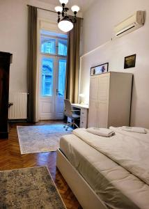 1 dormitorio con 2 camas, escritorio y ventana en Christoph's Central Apartment en Budapest