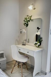 a white desk with a white chair and a mirror at Mammis Studios in Kardamaina