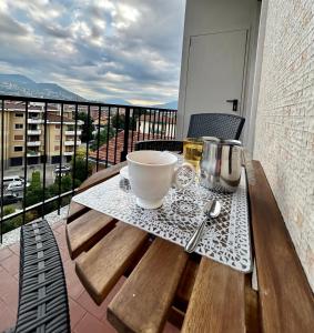 a wooden table with a bowl and spoon on a balcony at Lakehouse Enjoy in Verbania