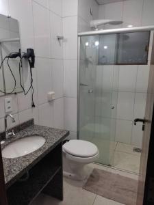 a bathroom with a shower and a toilet and a sink at Apartamento Park 1 in Dourados