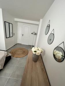 ein Wohnzimmer mit einem Tisch und Blumen an der Wand in der Unterkunft Appartement en rez-de-jardin in Vitry-sur-Seine