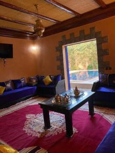 - un salon avec des canapés bleus et une table dans l'établissement villa sophie, à El Jemʼa Ghemat