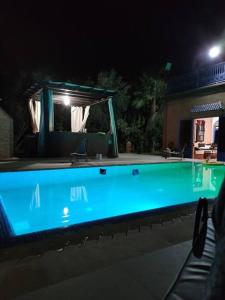 - une piscine éclairée la nuit dans l'établissement villa sophie, à El Jemʼa Ghemat