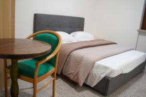 um quarto com uma cama com uma mesa e uma cadeira em Boccadoro Rooms em San Zeno