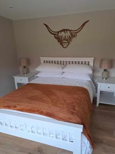 a bedroom with a large bed with two night stands at Rowan Bank Retreat in Fort Augustus