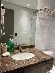 W łazience znajduje się umywalka i lustro. w obiekcie Flat Higienópolis Premium w São Paulo