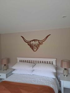 a bedroom with a bed with a crest on the wall at Rowan Bank Retreat in Fort Augustus