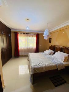 una camera da letto con un letto grande e una finestra di A Fineshade Apartment a Jinja