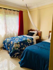 una camera da letto con due letti e una finestra di A Fineshade Apartment a Jinja