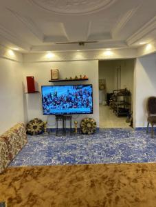 a living room with a large flat screen tv at شاليه ورد in Al Madinah